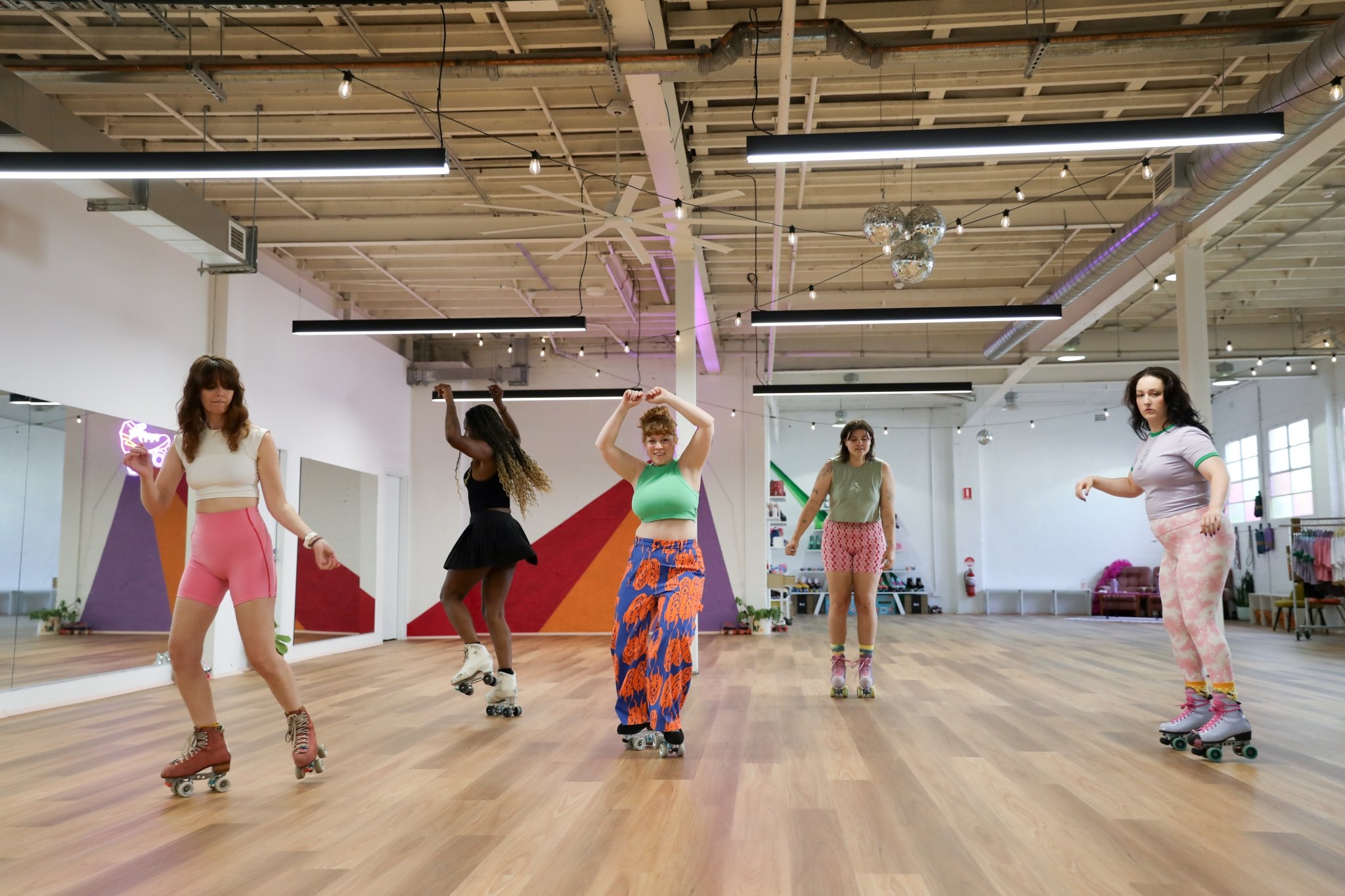 5 roller skaters at RollerMart studio doing roller dance and rhythm skating.